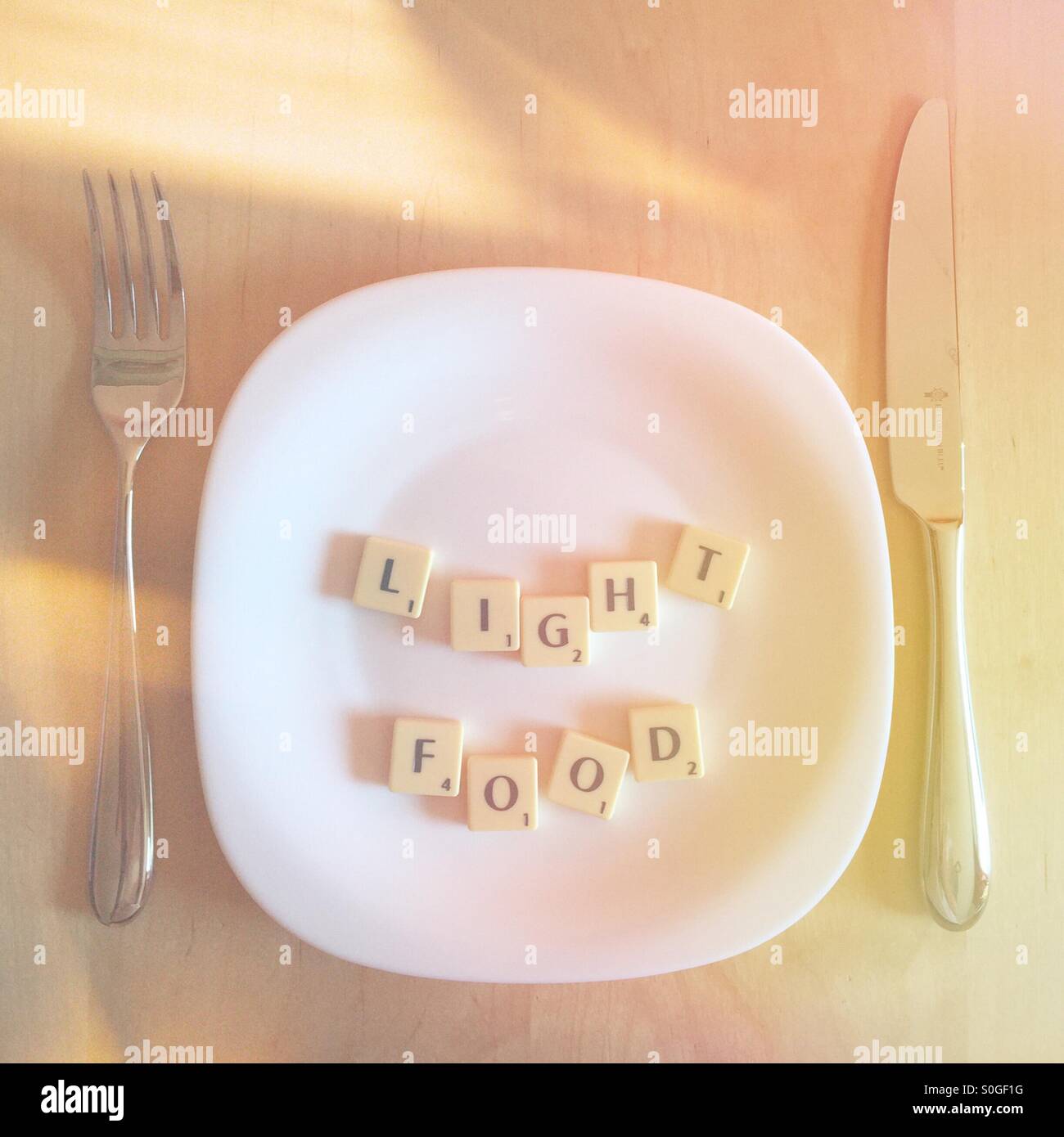 Platte mit dem Scrabble Wörter Licht Essen Stockfoto