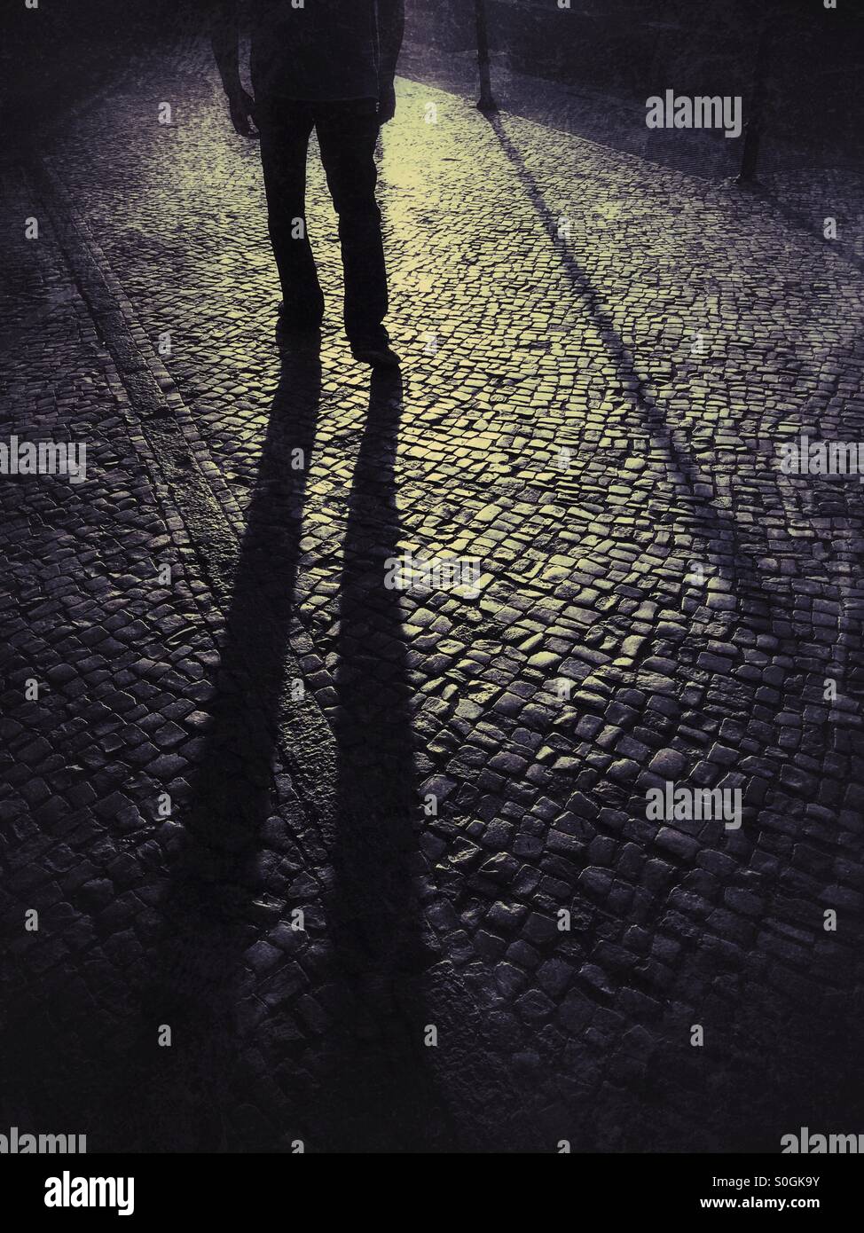 Schattenhafte männliche Figur auf der Straße Stockfoto