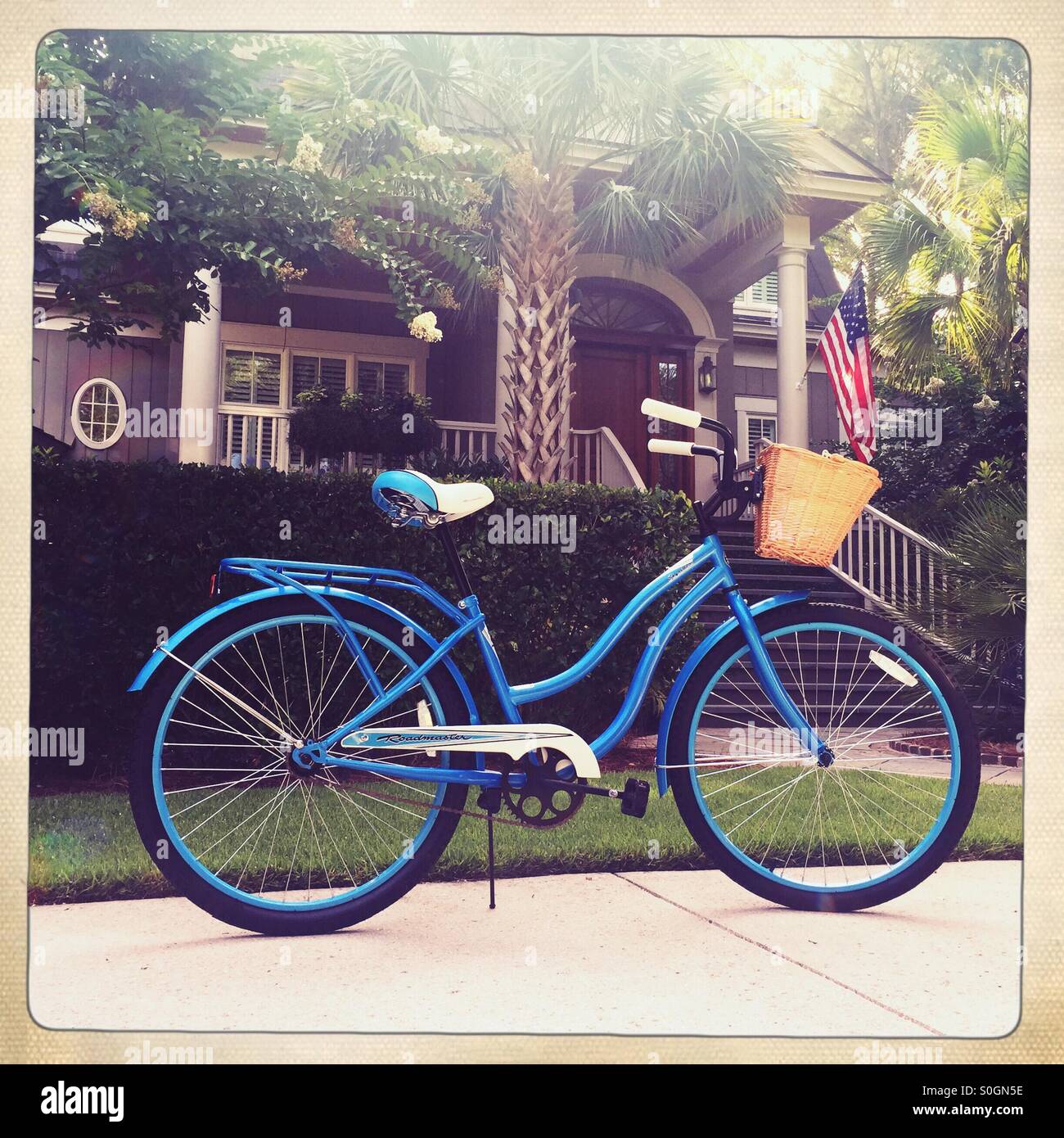 Ein blauer Strand Fahrrad mit einem Weidenkorb sitzt vor einem Lowcountry South Carolina nach Hause. Stockfoto