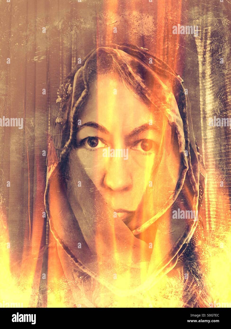 Frau mit Kapuze in Flammen Stockfoto