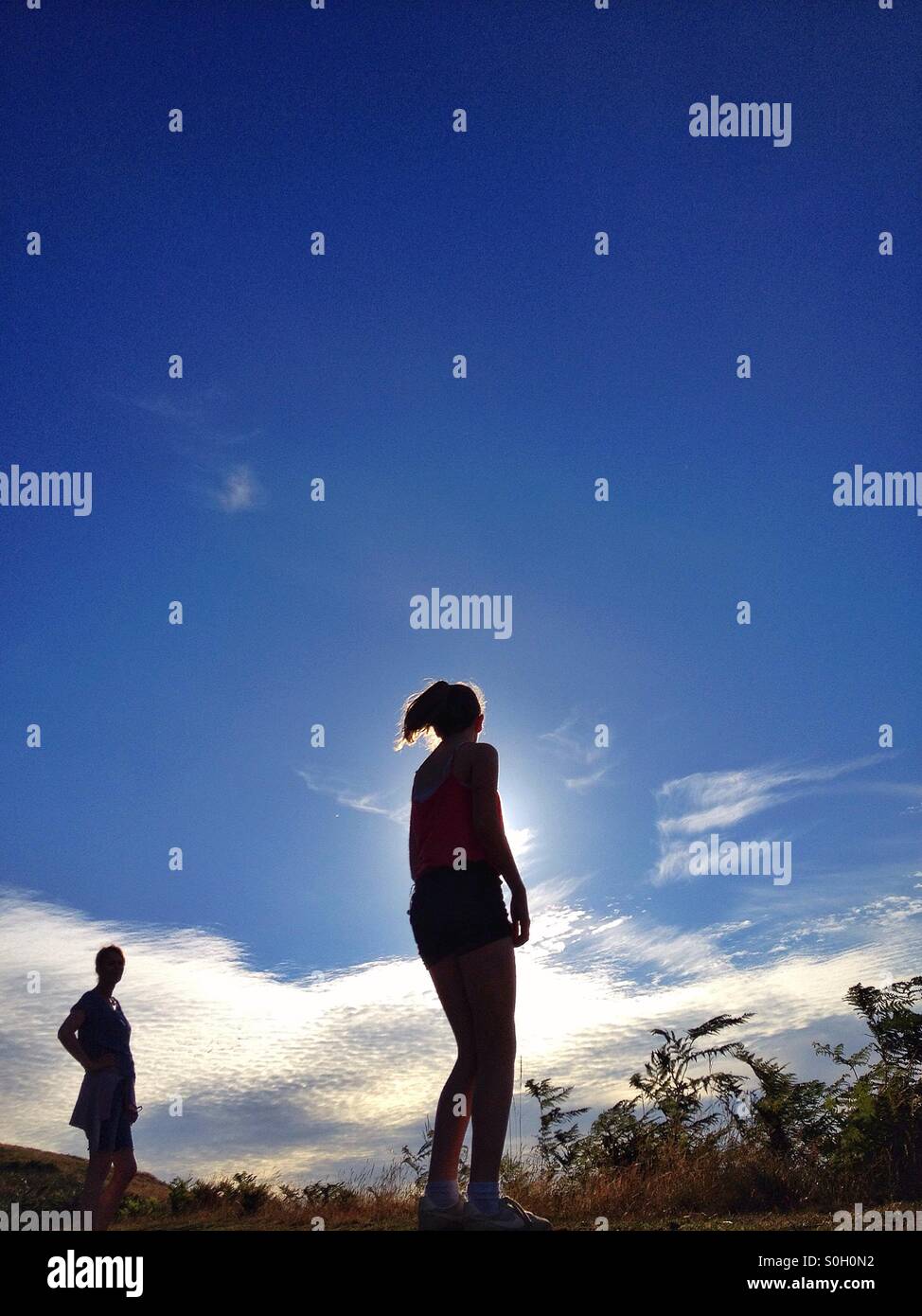 Mädchen gegen Sonne und blauer Himmel Stockfoto