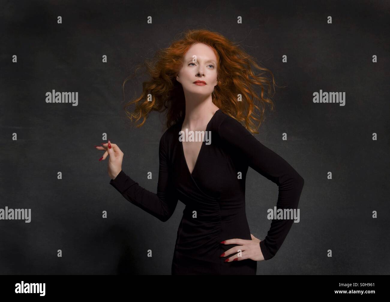 Rothaarige Model im schwarzen Kleid im studio Stockfoto