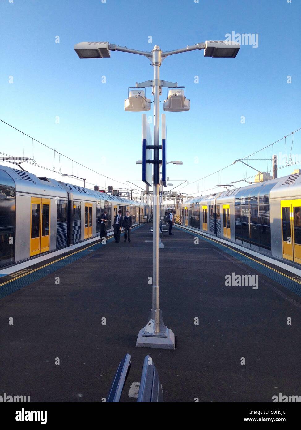 Milsons Point Railway Station, Sydney, Australien Aug. 2012: Personen, die zwei Züge von Sydney verlassen und auf beiden Seiten des Bahnsteigs einsteigen - Smartphone-aufgenommenes Stockfoto