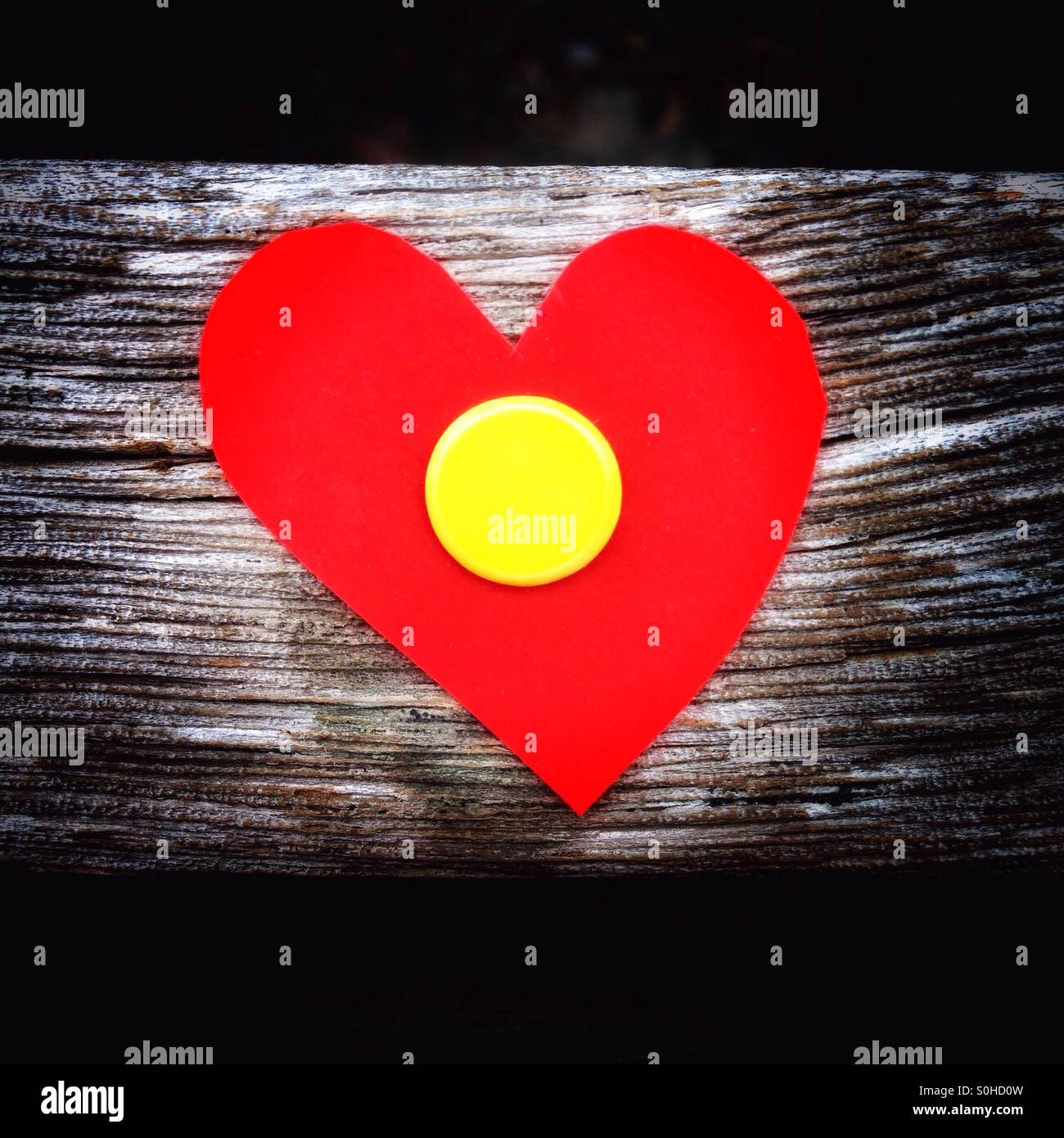 Kleine rote Herzen auf der Holzplatte einer Parkbank mit einem Stift befestigt Stockfoto