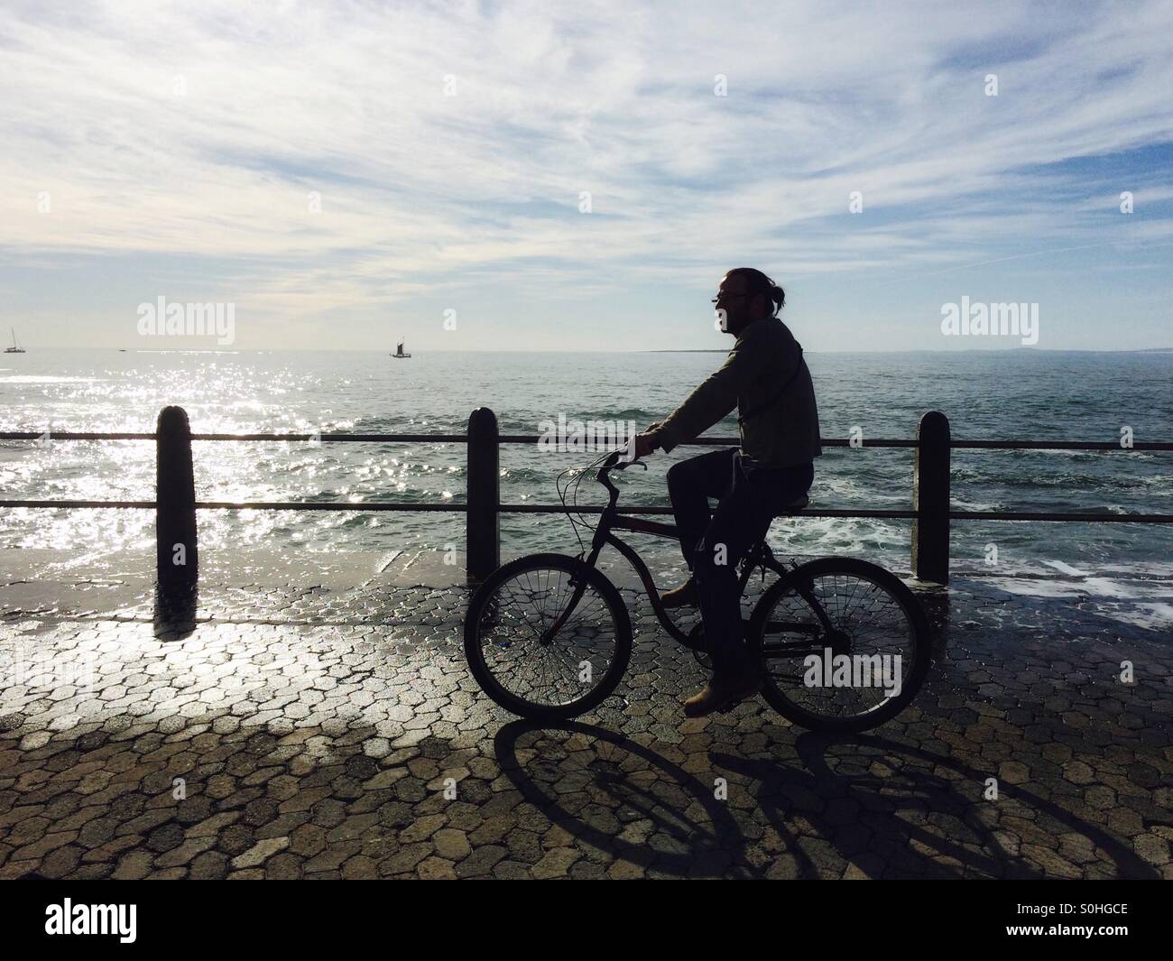 Mann Radfahren Seapoint Promenade, Süd-Afrika. - Smartphone-aufgenommenes Stockfoto