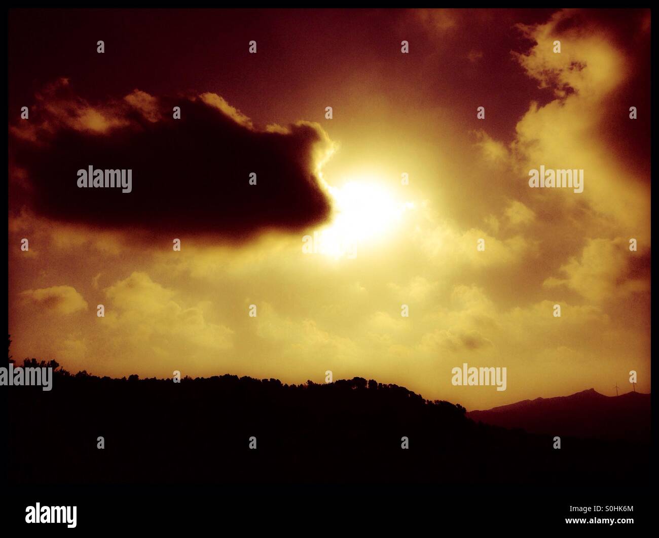 Die Sonne bricht hinter einer Wolke, Katalonien, Spanien. - Smartphone-aufgenommenes Stockfoto