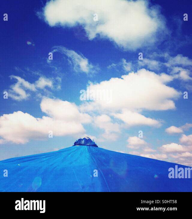 Ein blauer Schirm oben vor dem Hintergrund des blauen Himmels. Stockfoto