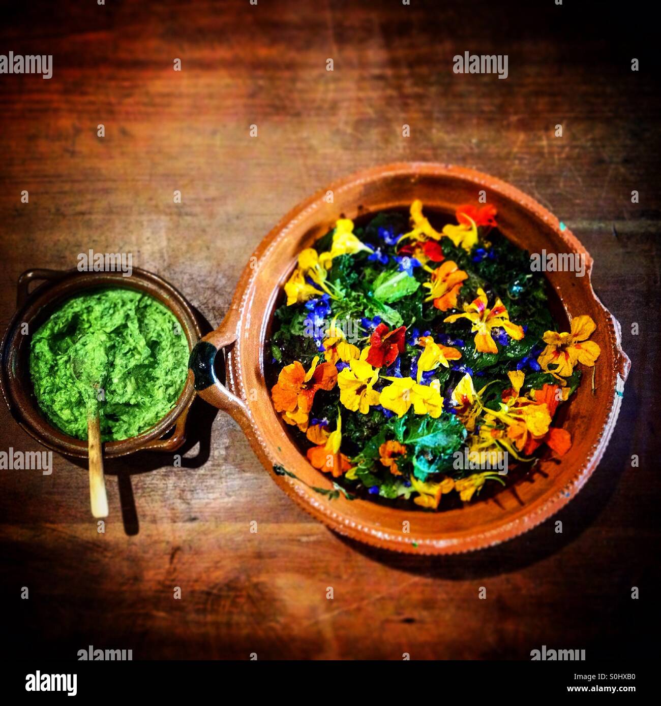 Eine organische Guacamole Sauce und einen frischen Salat dekoriert mit Blumen in Colonia Roma, Mexiko-Stadt, Mexiko - Smartphone-aufgenommenes Stockfoto
