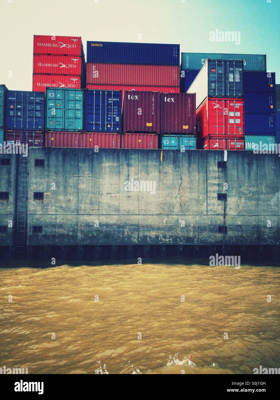 Container gestapelt im Hamburger Hafen, Deutschland vom Wasser aus gesehen - Smartphone-aufgenommenes Stockfoto