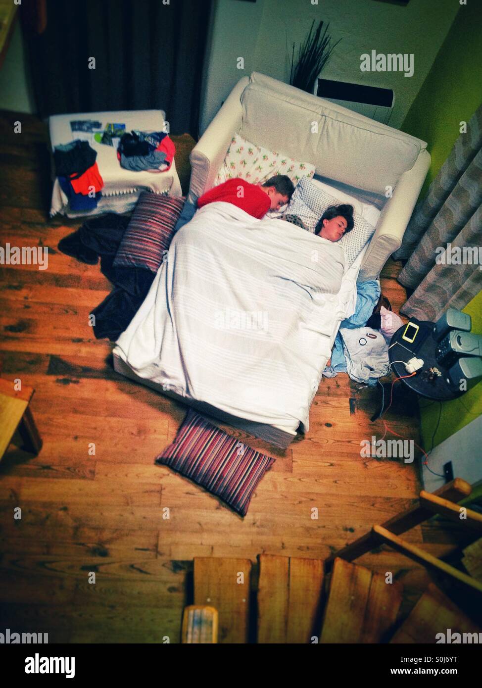 Jungen und Mädchen schlafend auf einem Sofa-Bett bei einem Airbnb in Italien Stockfoto
