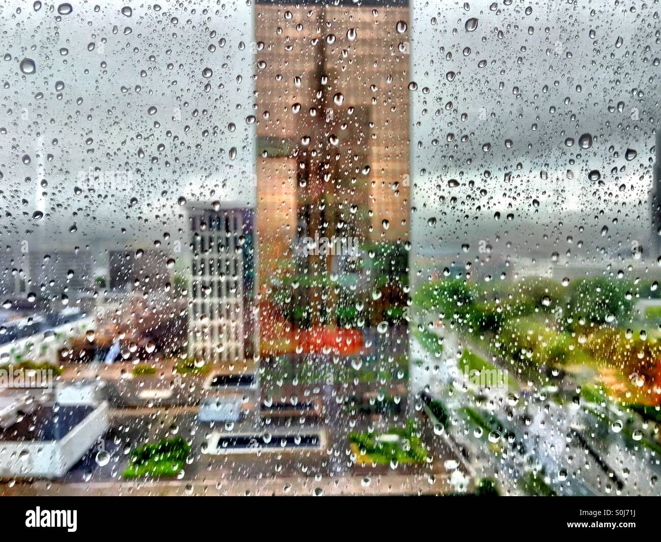 Stürmischen Stadt durch ein regnete Fenster Stockfoto