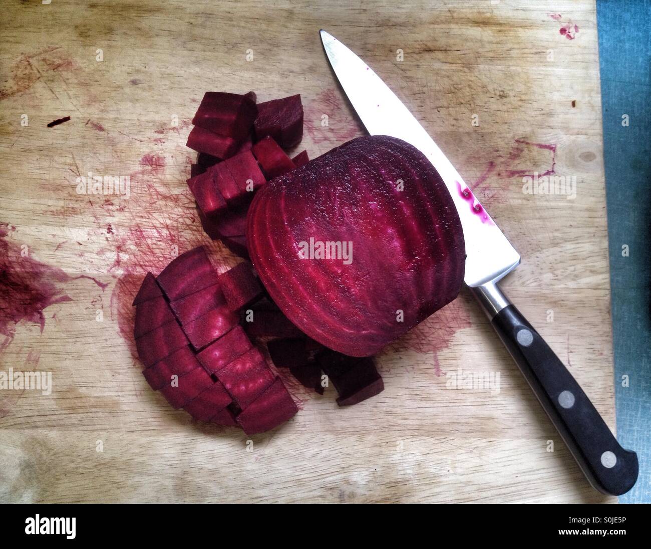 Gehackte rote Beete auf Schneidebrett - Smartphone-aufgenommenes Stockfoto