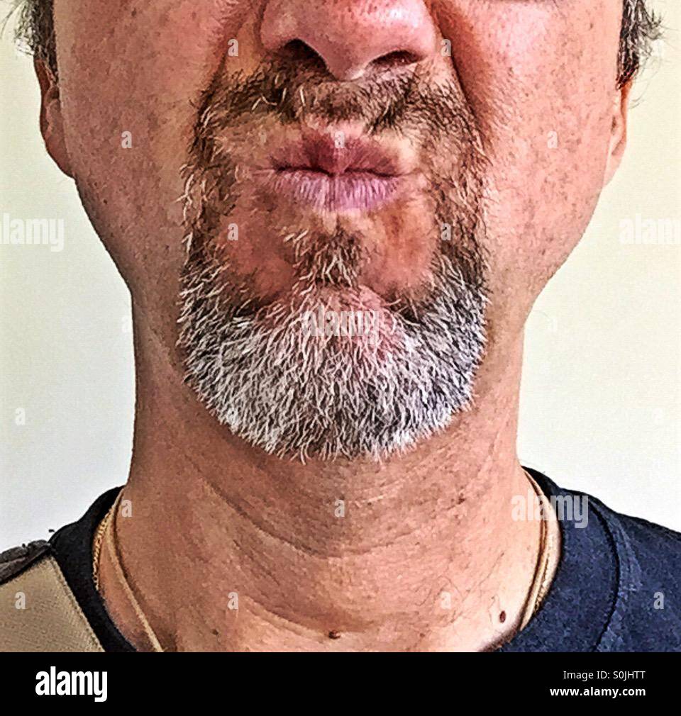 Porträt eines Mannes mit einem graumelierten Spitzbart angewidert schmerzverzerrtem Gesicht mit seinem Mund machen schneiden - Smartphone-aufgenommenes Stockfoto
