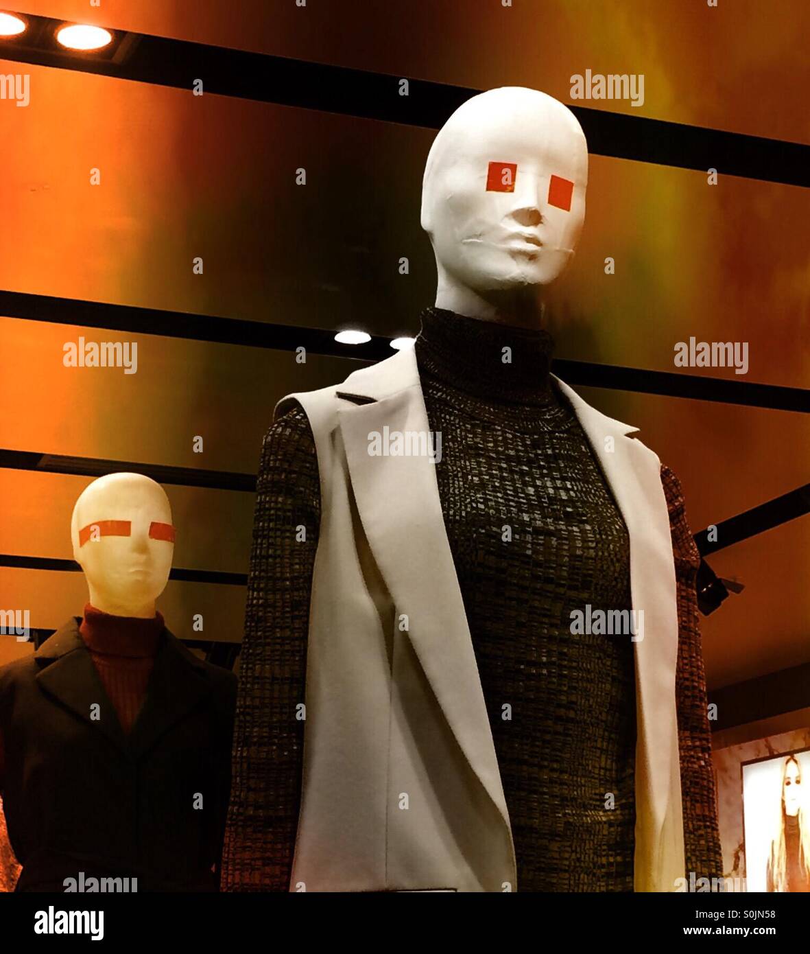 Shop-Mannequins mit orange Formen für die Augen. - Smartphone-aufgenommenes Stockfoto