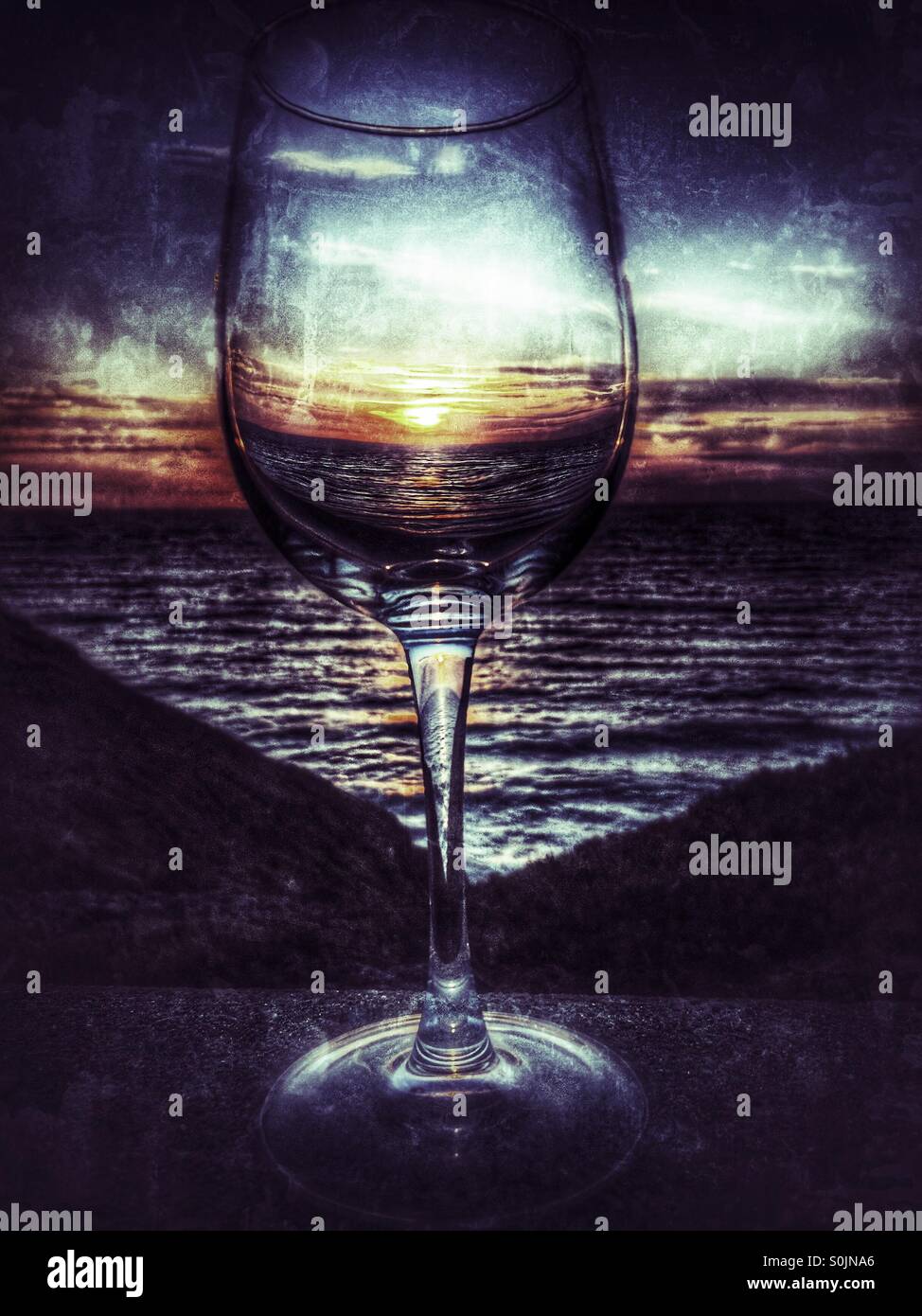 Sonnenuntergang über einem Glas Wein Stockfoto
