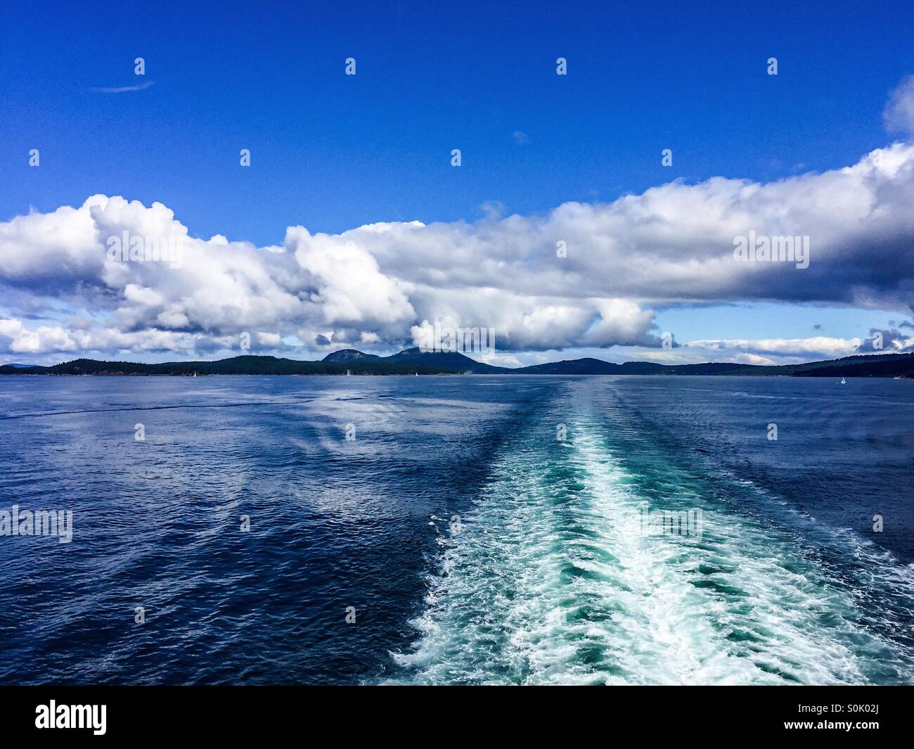 Rückblick auf Gefolge durch die Passage eines Bootes verursacht. Land ist im Hintergrund sichtbar. - Smartphone-aufgenommenes Stockfoto