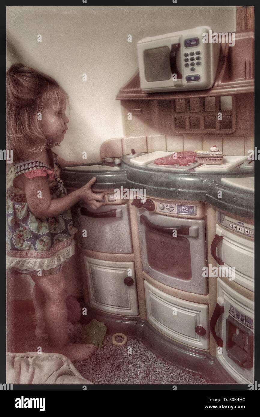 Kleines Mädchen Kochen in der Spielküche Stockfoto