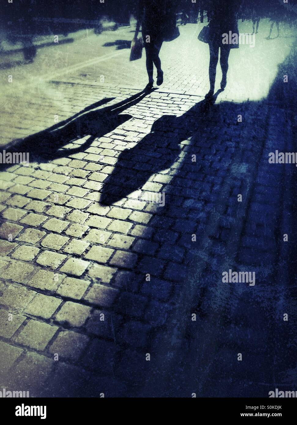 Schatten der Frauen auf eine Straße - Smartphone-aufgenommenes Stockfoto