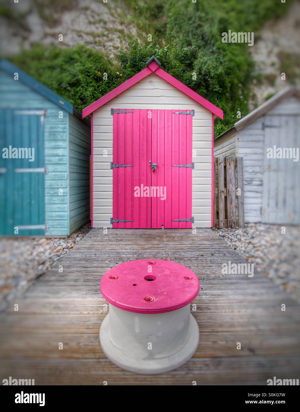 Eine Strandhütte mit einer rosa Tür in Devon, England. Stockfoto