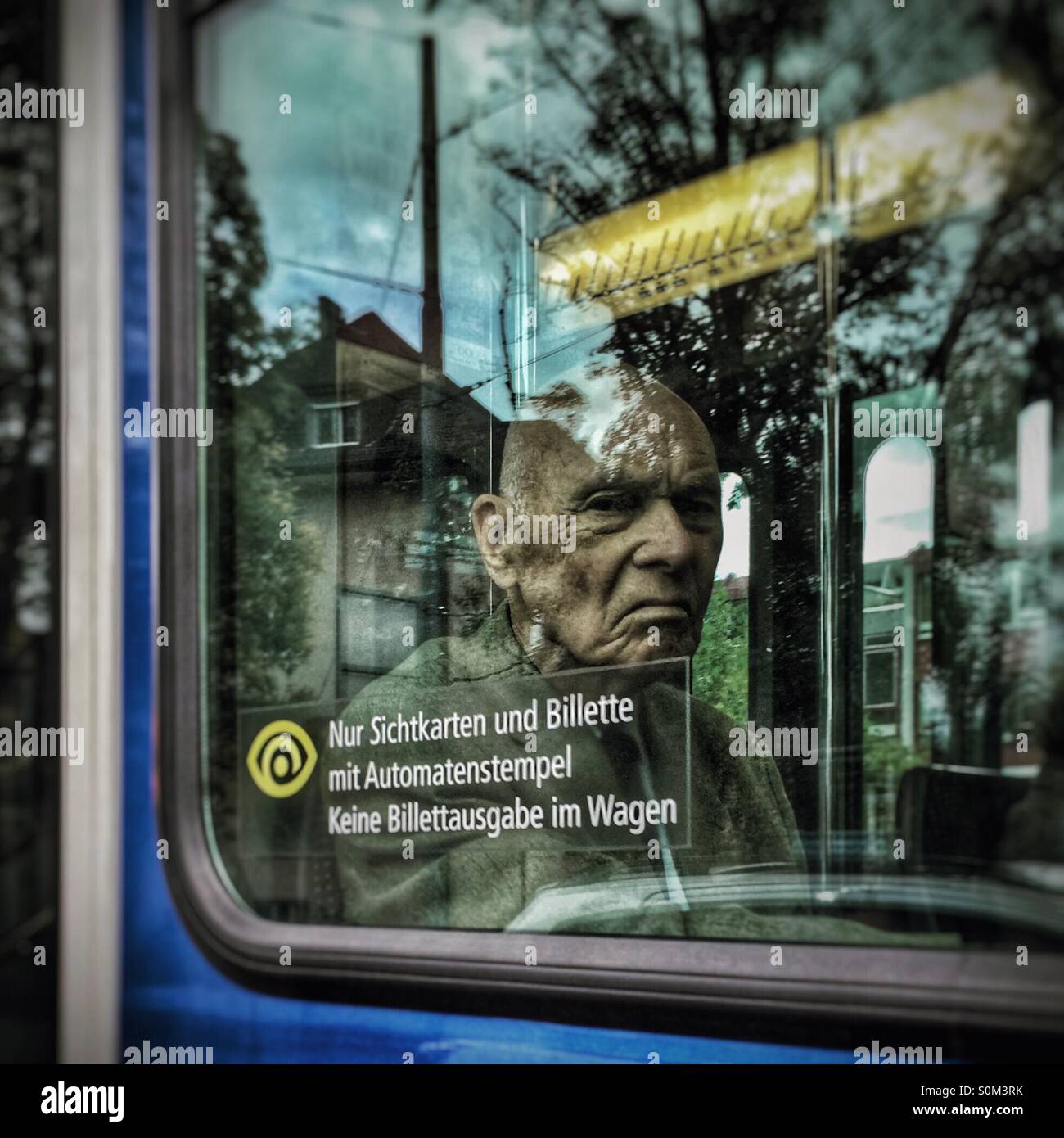 Sauer-faced Greis Wassilij durch eine Straßenbahn-Fenster Stockfoto