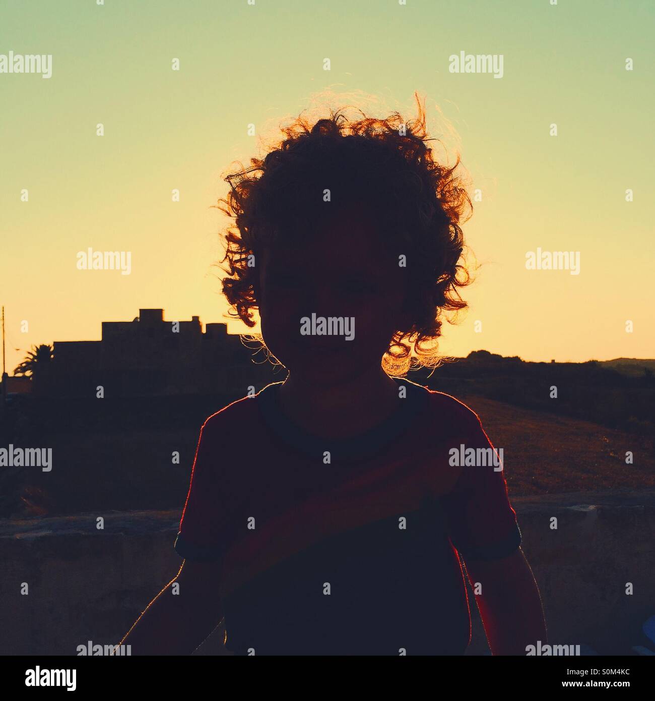Leuchtende Silhouette eines jungen mit Sonnenuntergang im Hintergrund Stockfoto
