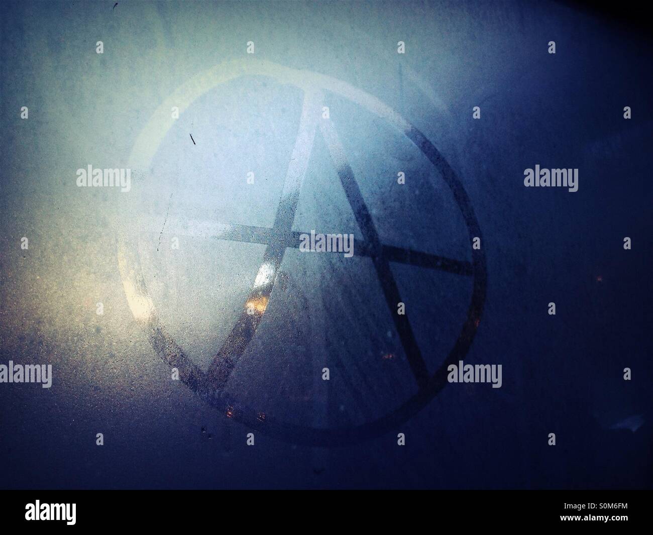 Anarchie-Symbol gezeichnet in Kondenswasser am Fenster der Wartehalle - Smartphone-aufgenommenes Stockfoto