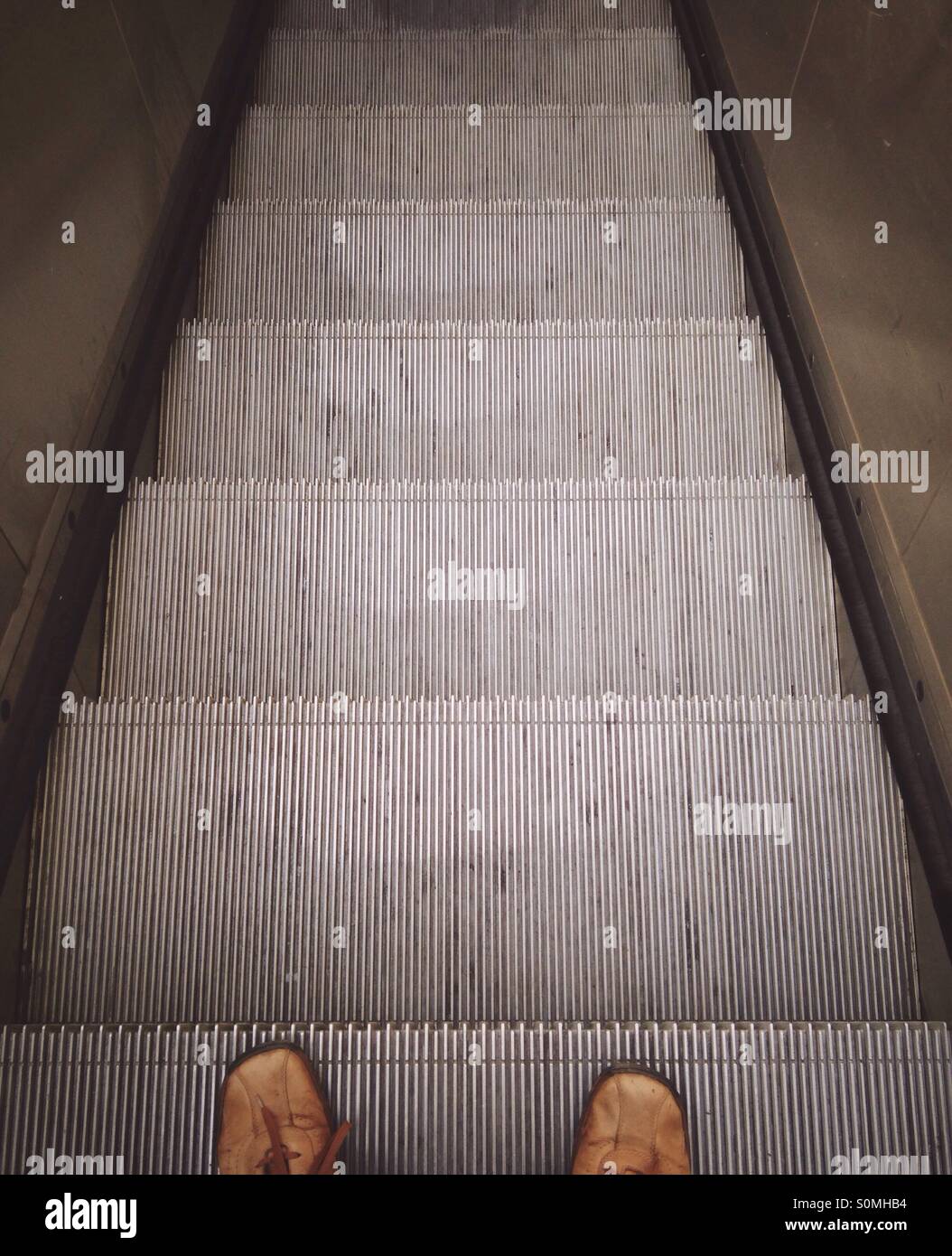 Füße auf Rolltreppe aus Sicht Stockfoto