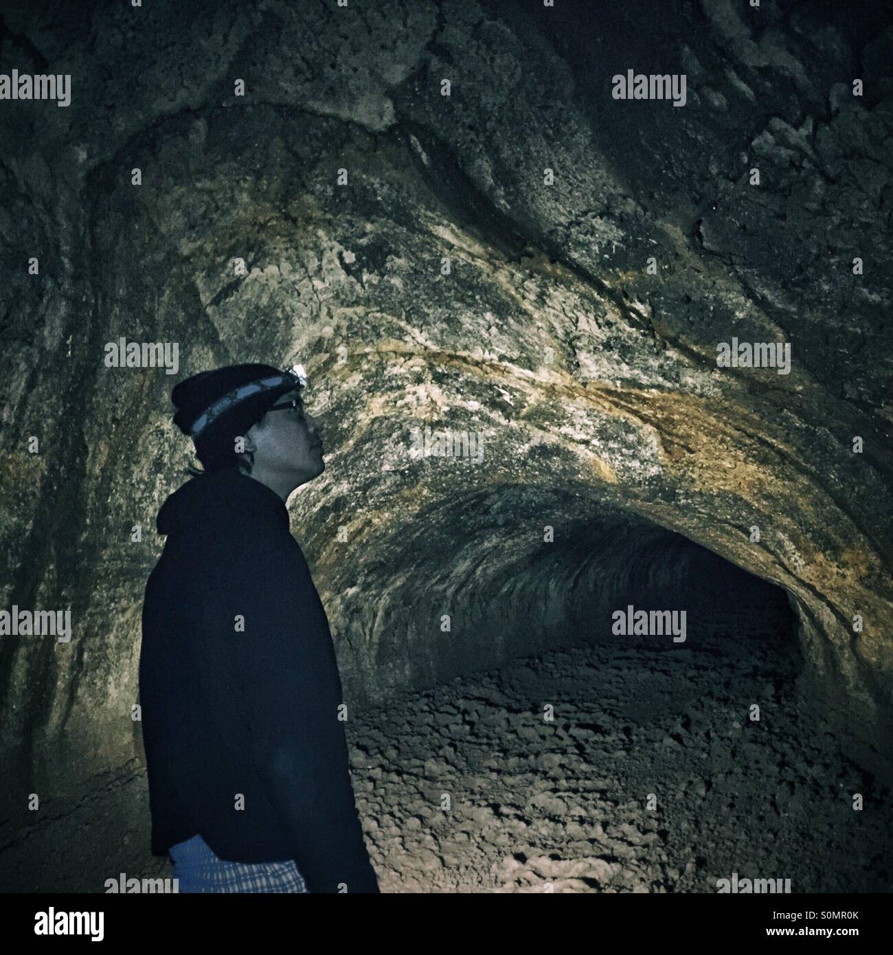 Mann sucht eine Ehrfurcht an den Wänden der Lavatunnel in Ape Cave im US-Bundesstaat Washington Stockfoto