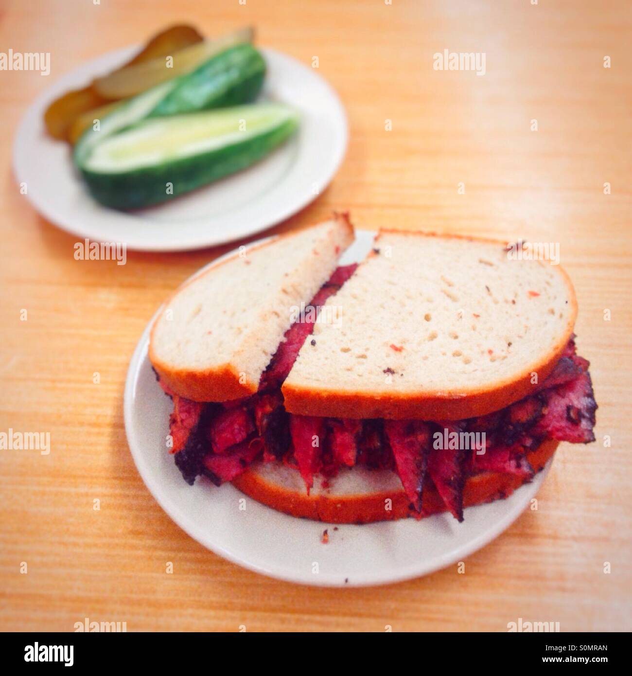 Pastrami auf Roggen-Sandwich mit einer Seitenlänge von Gurken, Katz Feinkost, Manhattan, New York City, Vereinigte Staaten von Amerika. - Smartphone-aufgenommenes Stockfoto