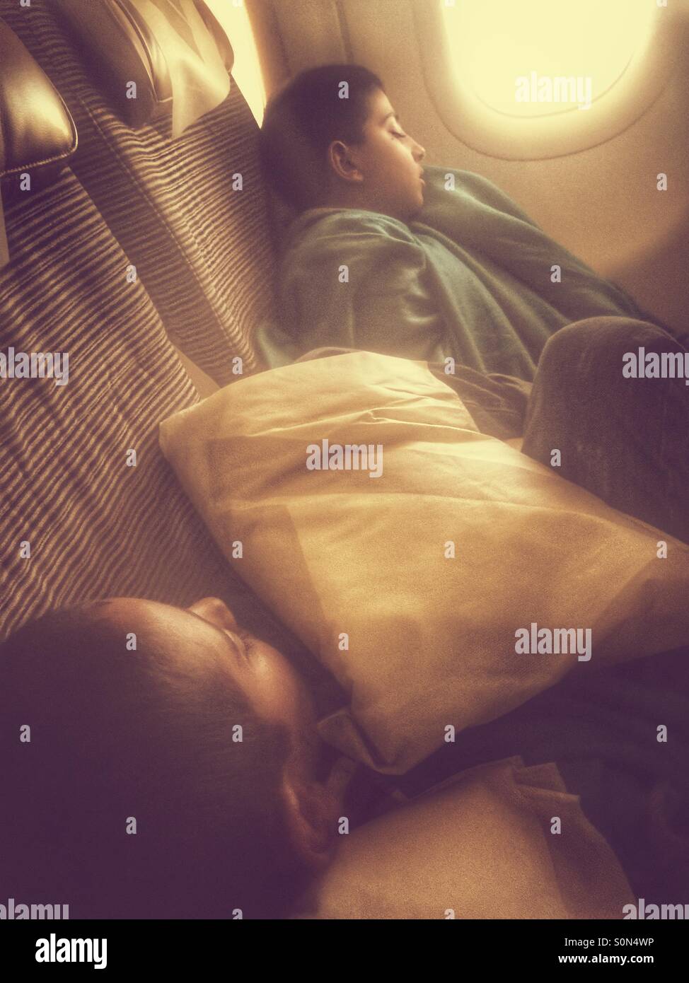 Zwei Jungen schlafen im Flugzeug - Smartphone-aufgenommenes Stockfoto