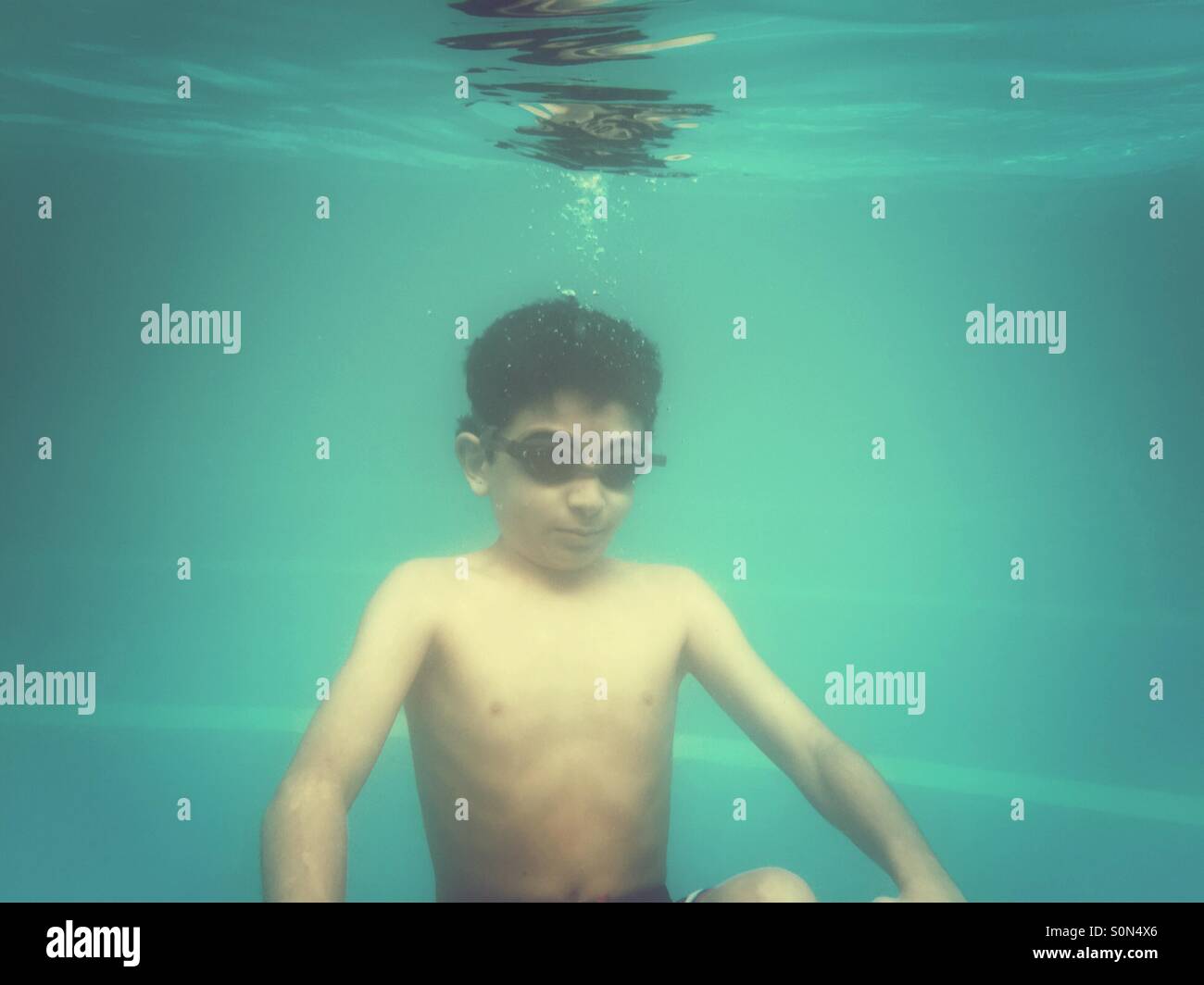 10 Jahre alten Jungen schwimmen unter Wasser im pool Stockfoto