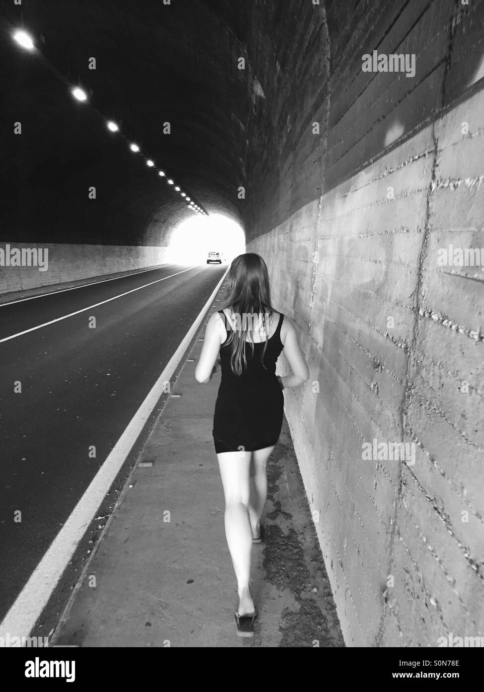 Schwarz / weiß-Bild von einem Mädchen zu Fuß durch einen tunnel Stockfoto