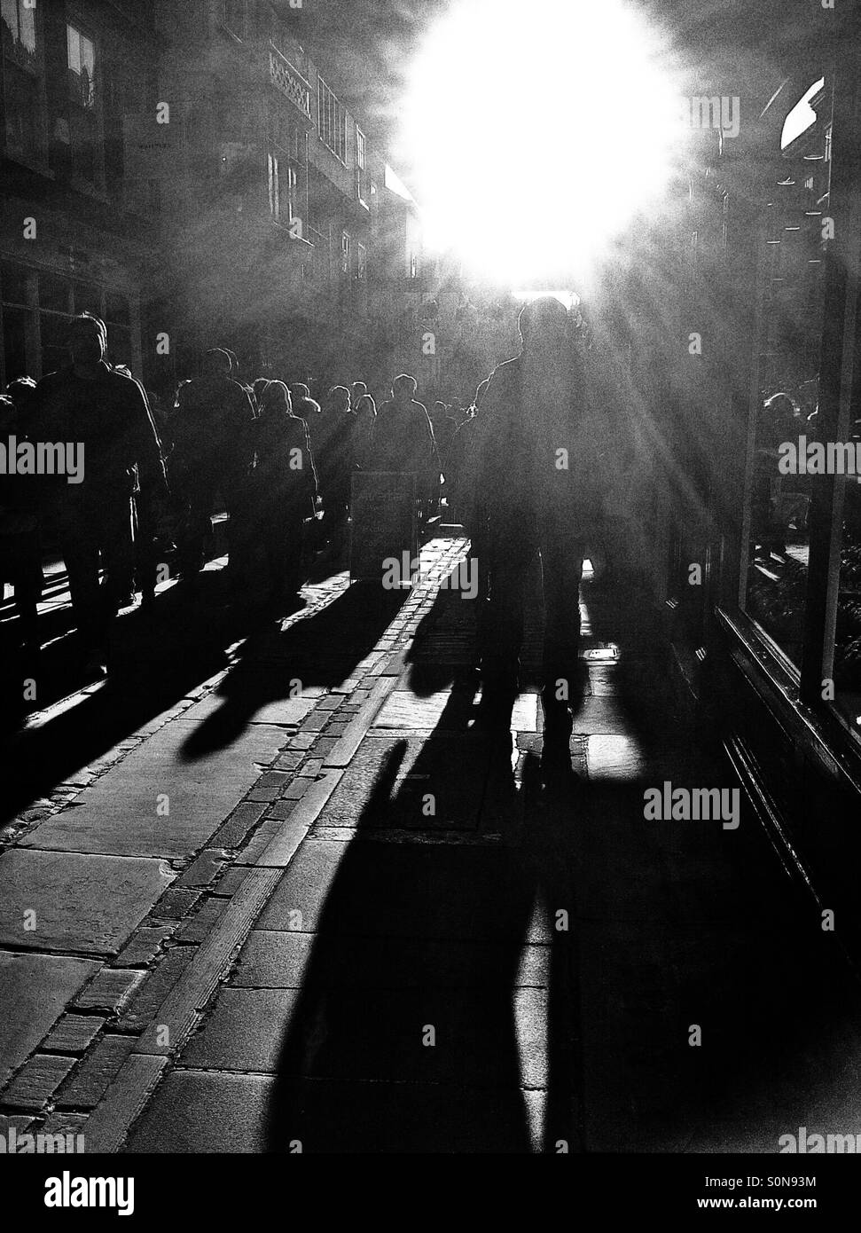 Silhouetten von Menschen entlang der gepflasterten Straße England UK - Smartphone-aufgenommenes Stockfoto