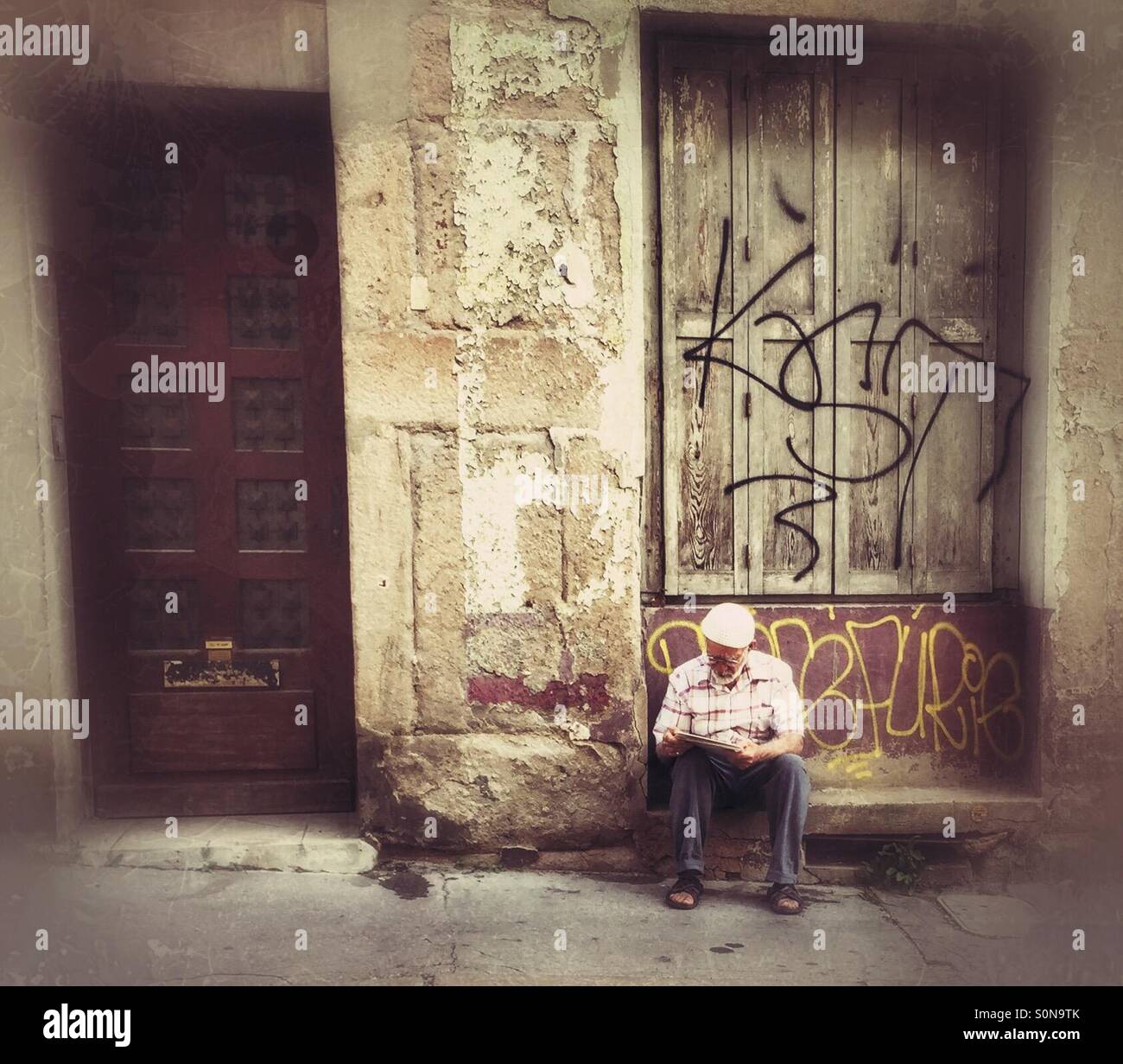 Alte Mann liest Zeitung, Straße Frankreich Stockfoto