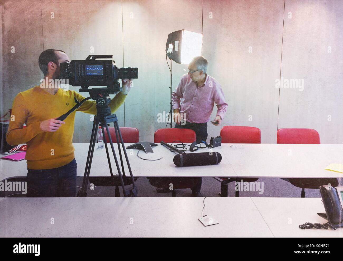 Kamerateam, die Vorbereitung zu einem Interview in einem meeting-Raum Büro schießen - Smartphone-aufgenommenes Stockfoto