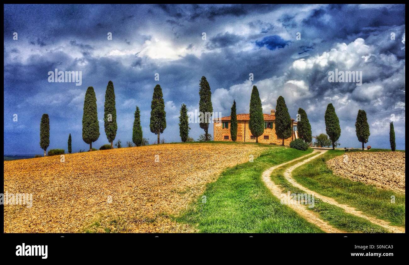 Einen klassischen toskanischen Landschaft Blick. Ein Bauernhaus in der Nähe von Pienza, "bewacht" von den berühmten Zypressen in der Val d ' Orcia, Toskana, Italien. Bildnachweis - © COLIN HOSKINS. - Smartphone-aufgenommenes Stockfoto