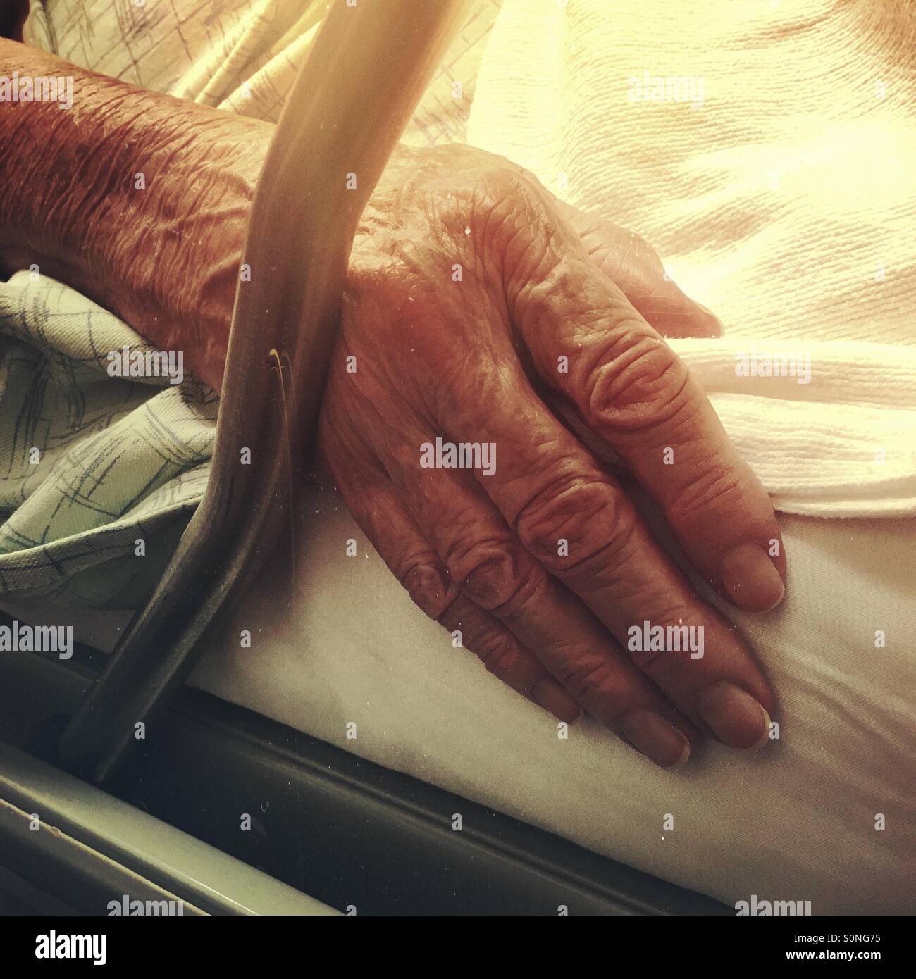 Eine ältere Dame Hand auf der Seite ein Krankenhausbett. - Smartphone-aufgenommenes Stockfoto