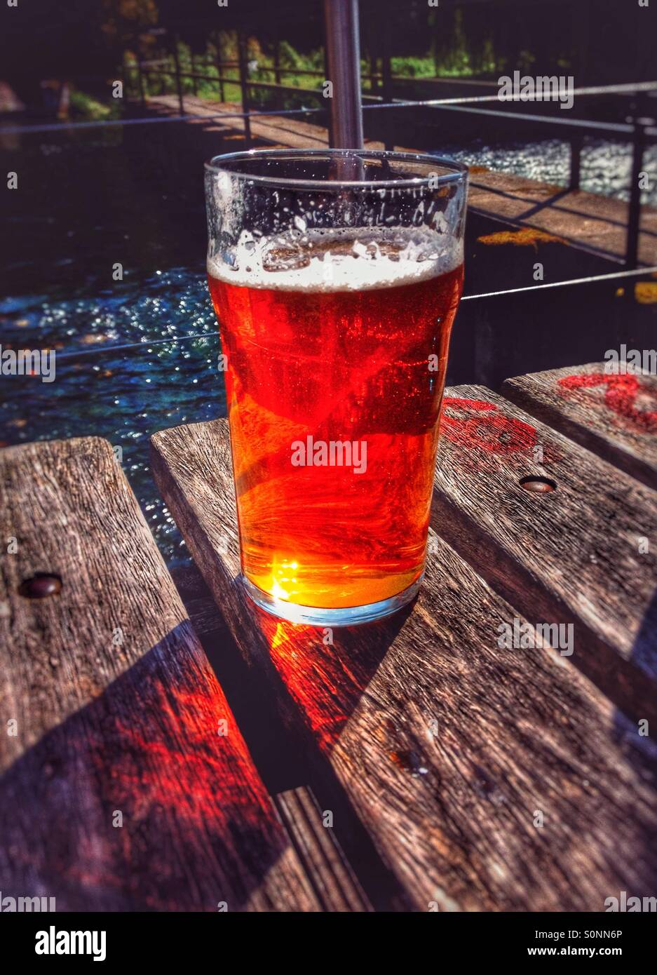 Pint Bier auf riverside Bank Stockfoto