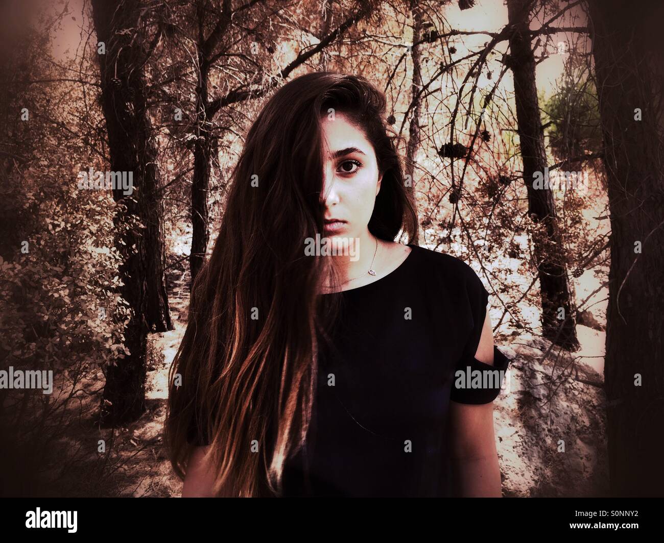 Junge Teenager-Mädchen Haar bedeckte Gesicht im Wald Stockfoto