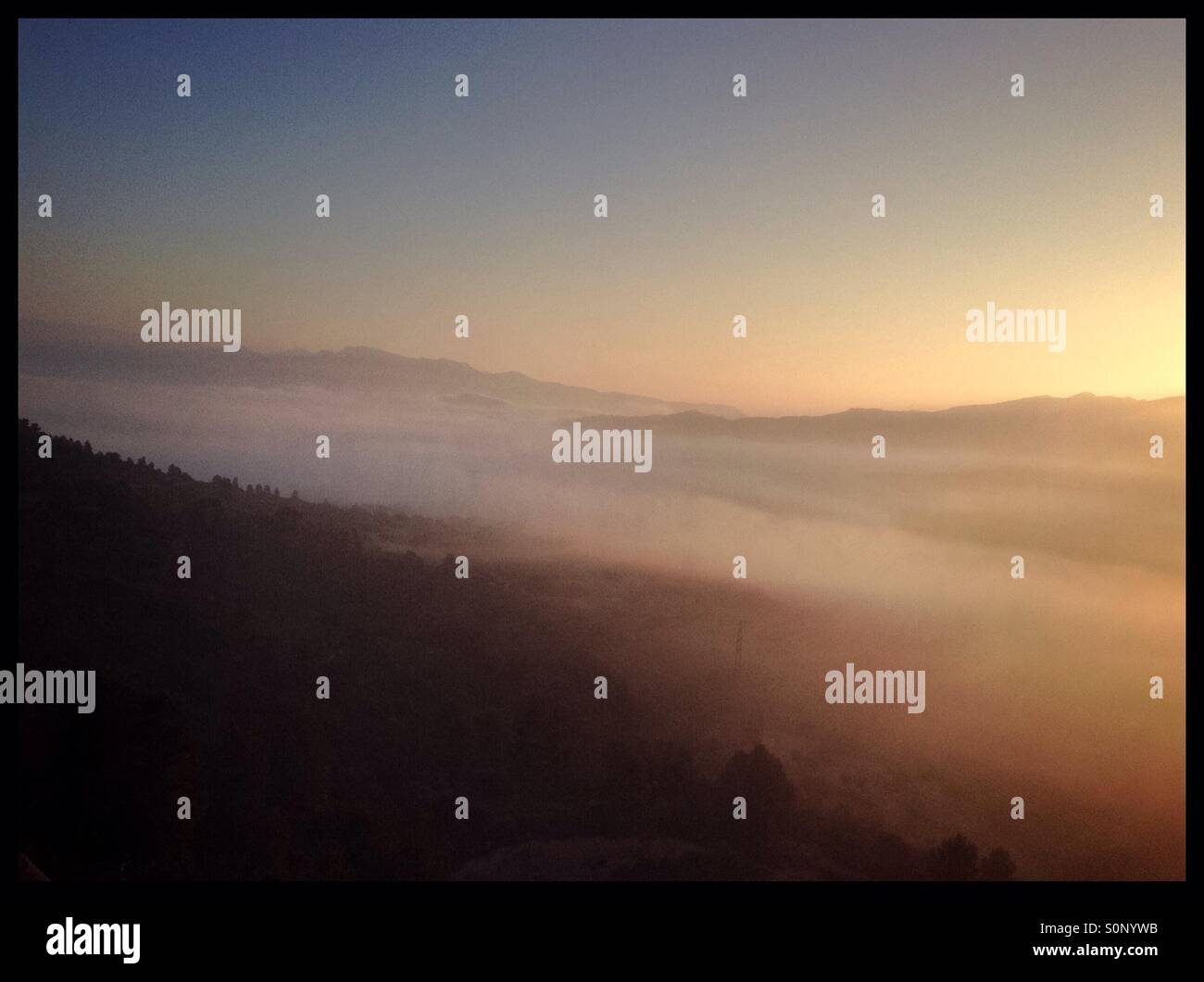 Sonnenaufgang über dem Nebel gefüllt Tal mit einem nebligen Bergblick, Katalonien, Spanien. Stockfoto