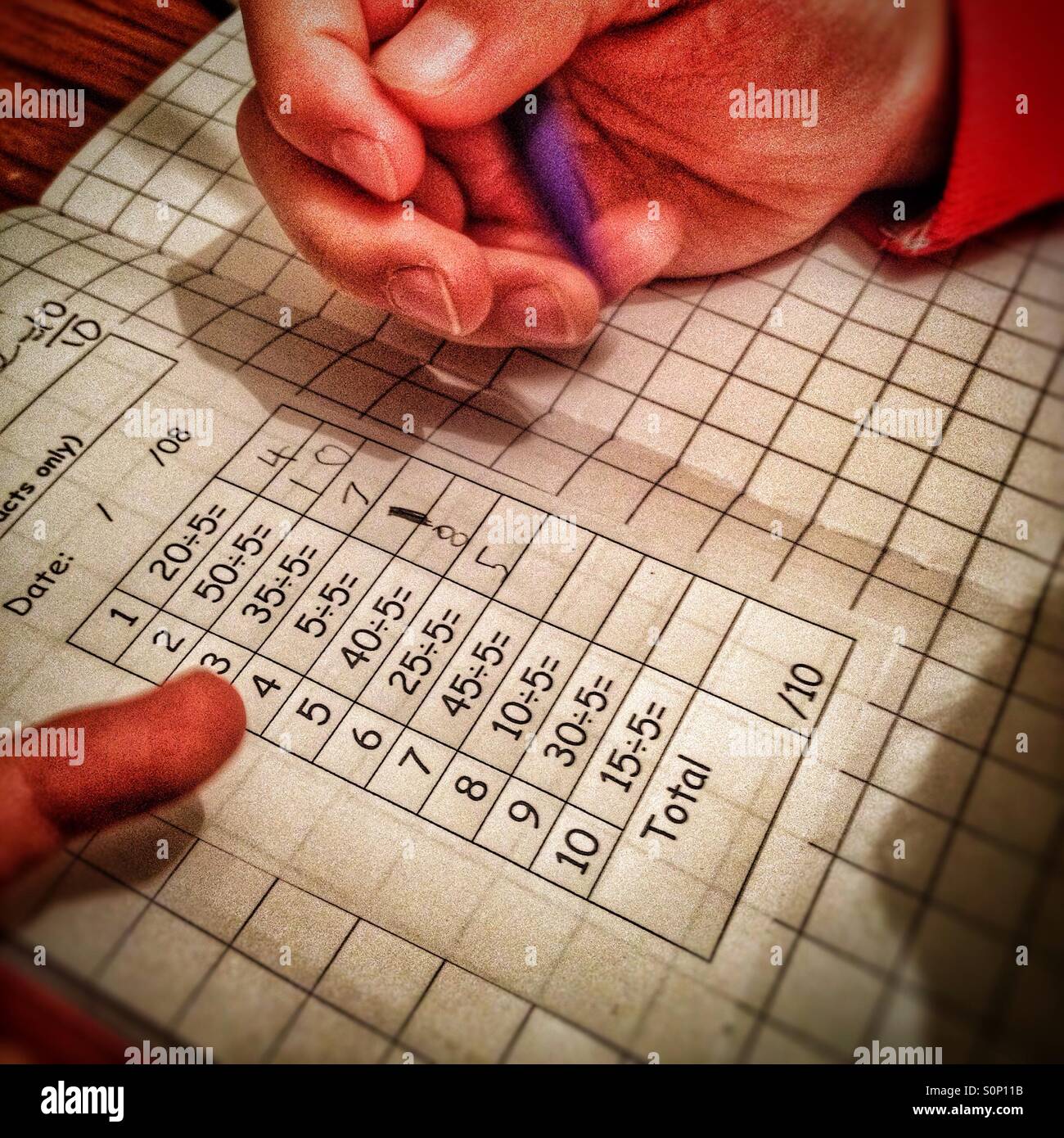 Ein Kind tun Mathe Hausaufgaben. - Smartphone-aufgenommenes Stockfoto