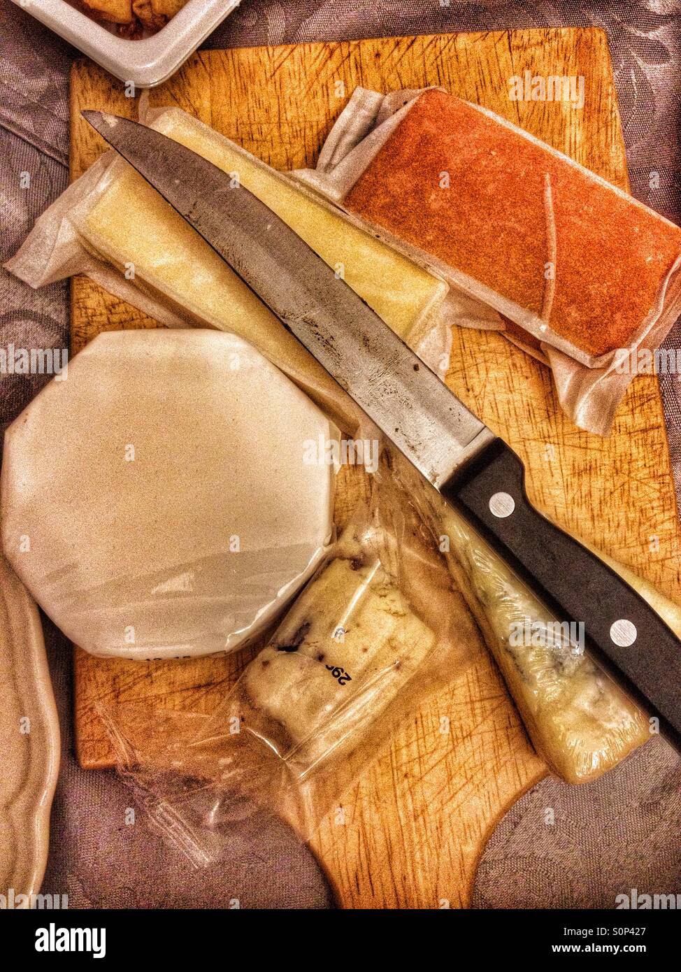 Käse und einem scharfen Messer auf einem Käse vom Brett. - Smartphone-aufgenommenes Stockfoto