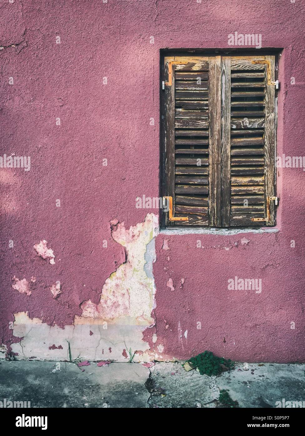 Verwitterte Fassade mit geschlossenen Holzfenster - Smartphone-aufgenommenes Stockfoto