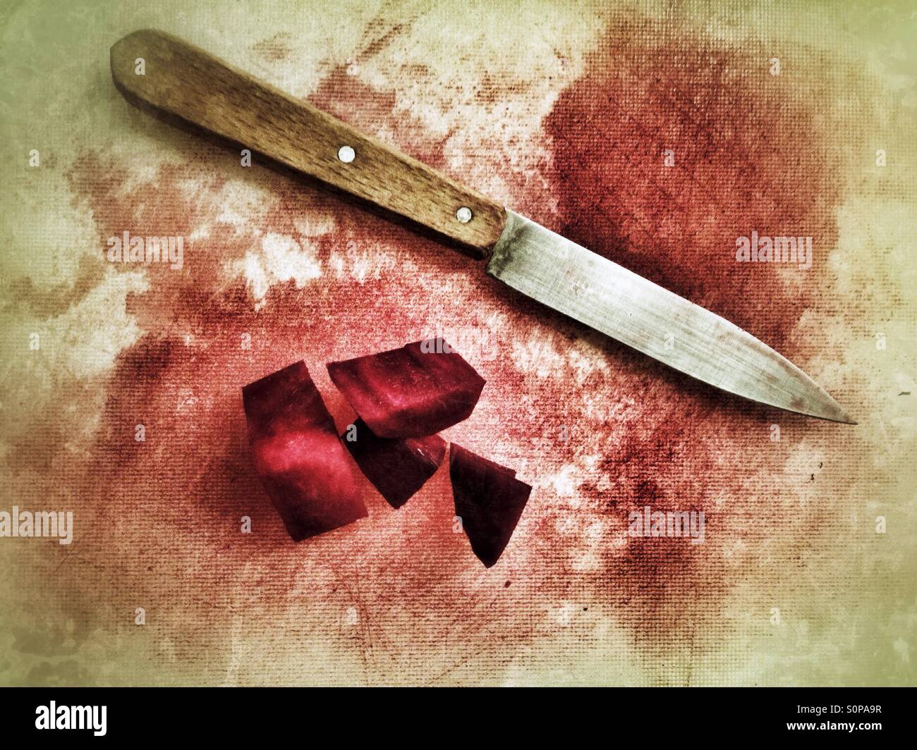 Rote Beete zerschnitten und ein Messer auf ein Kunststoff Schneidebrett sieht aus wie geschlachtet Stockfoto