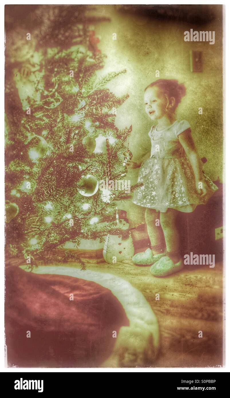 Glückliche kleine Mädchen Blick auf den Weihnachtsbaum Stockfoto