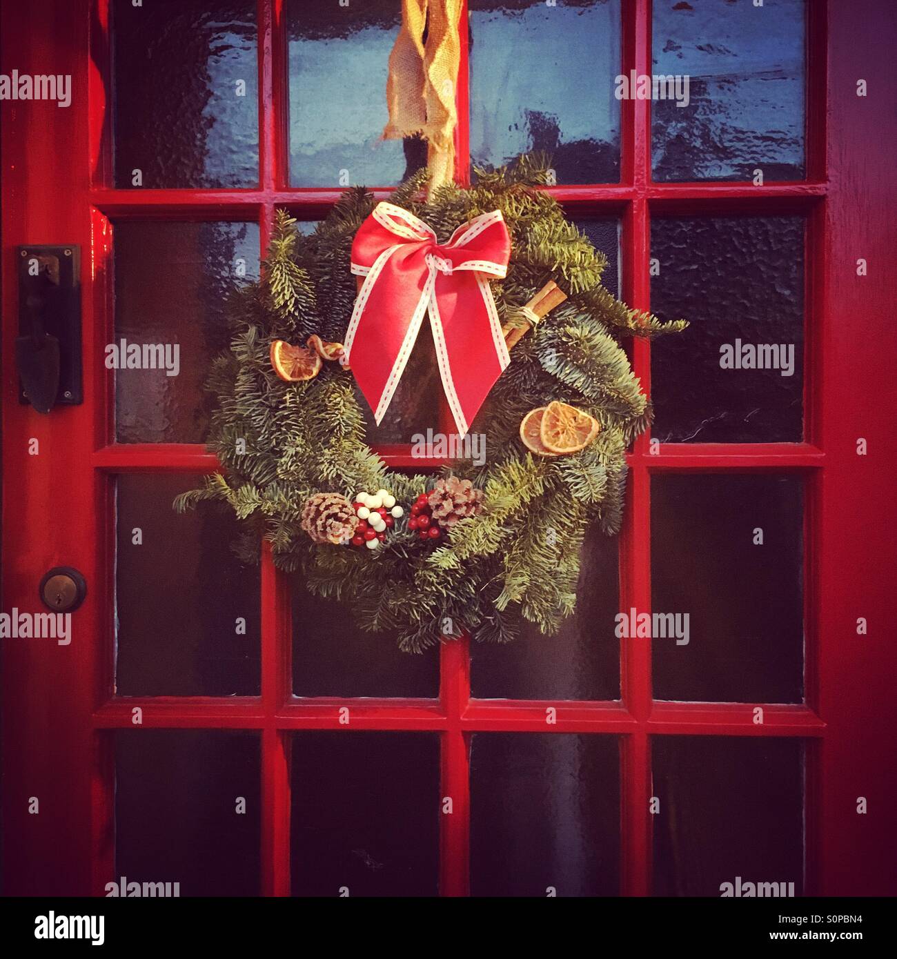 Weihnachtskranz hängen rote Tür Stockfoto