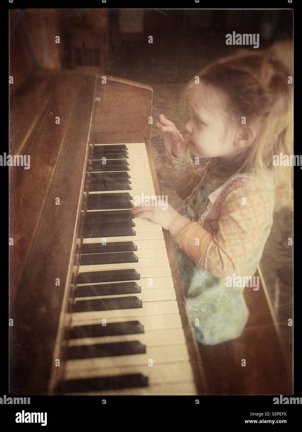 Kleines Mädchen mit dem Klavierspiel Stockfoto
