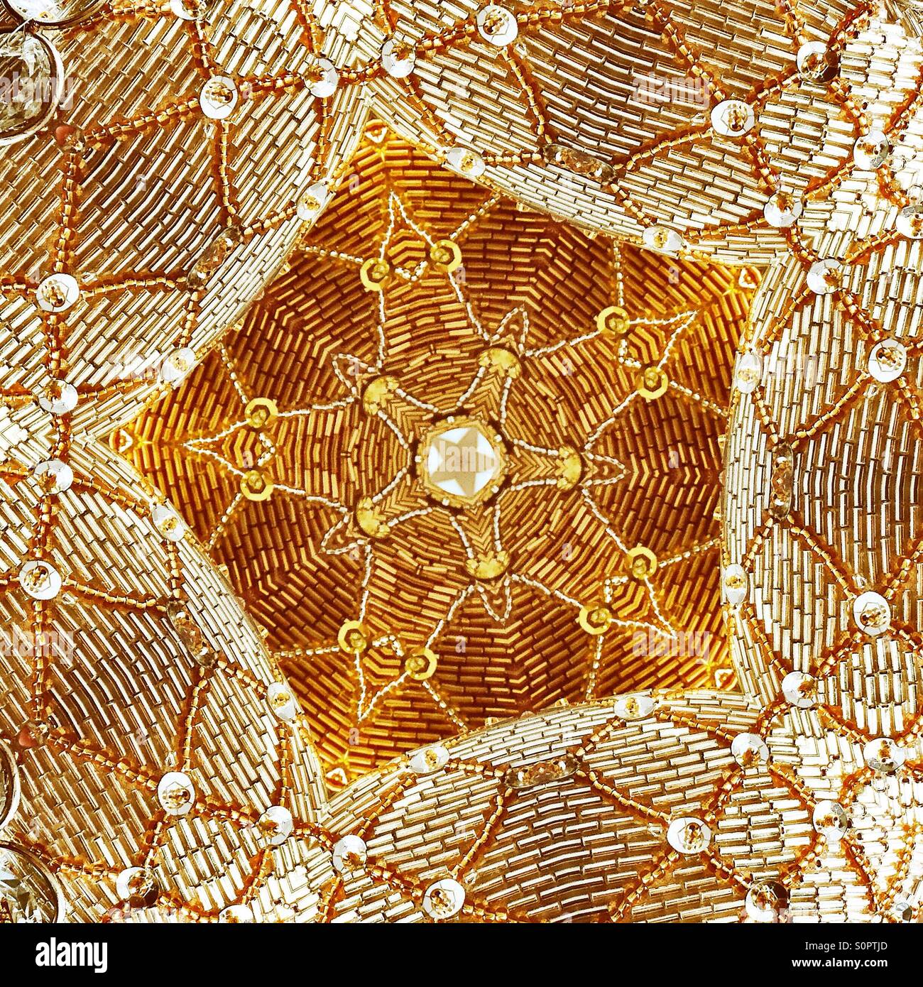Ein Makro-Ansicht ein Pailletten kaleidoskopartigen Bild des goldenen und weißen sternförmig. Stockfoto
