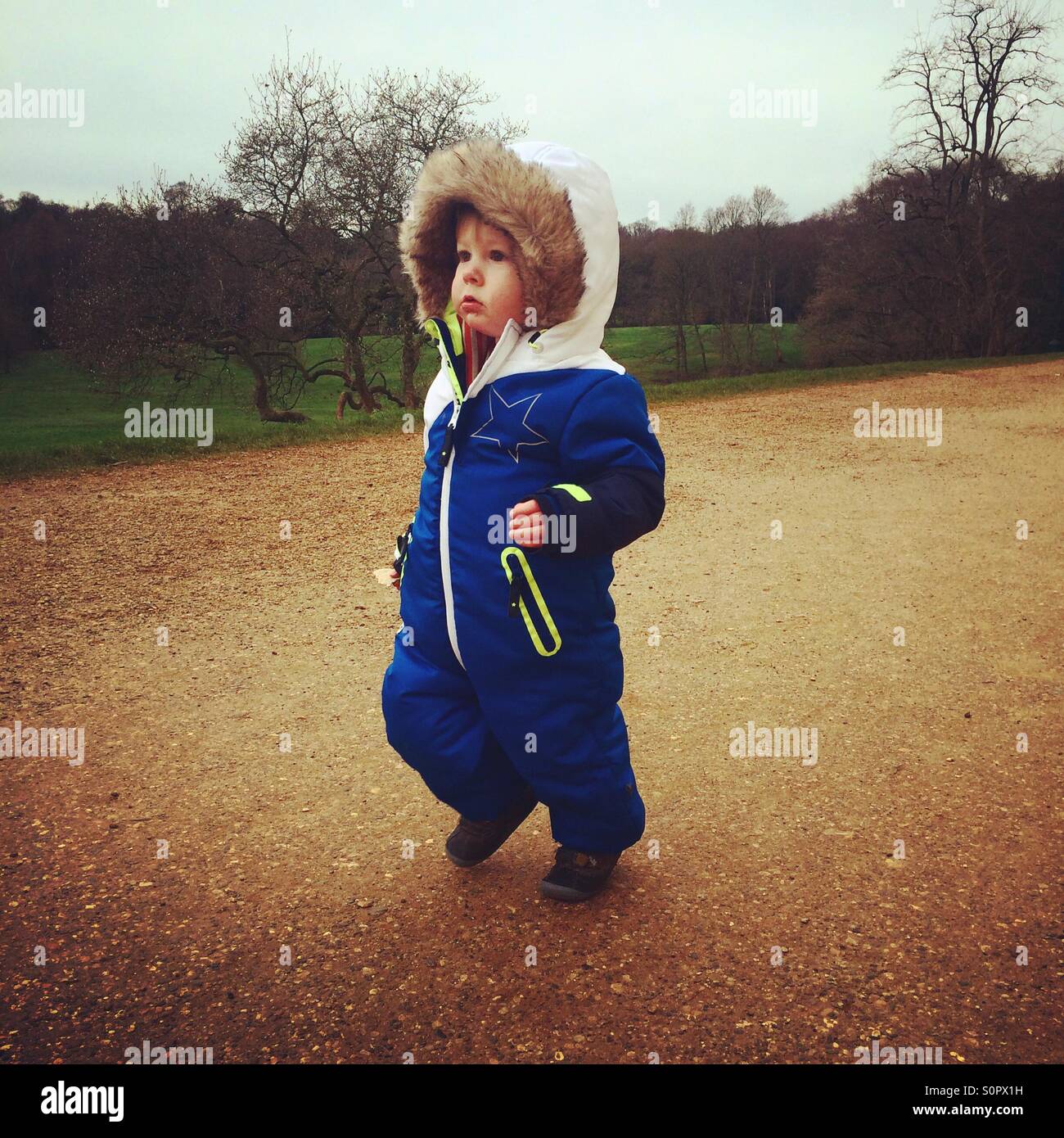 Kleinkind Jungen laufen in ein Winter-Strampler im park Stockfoto