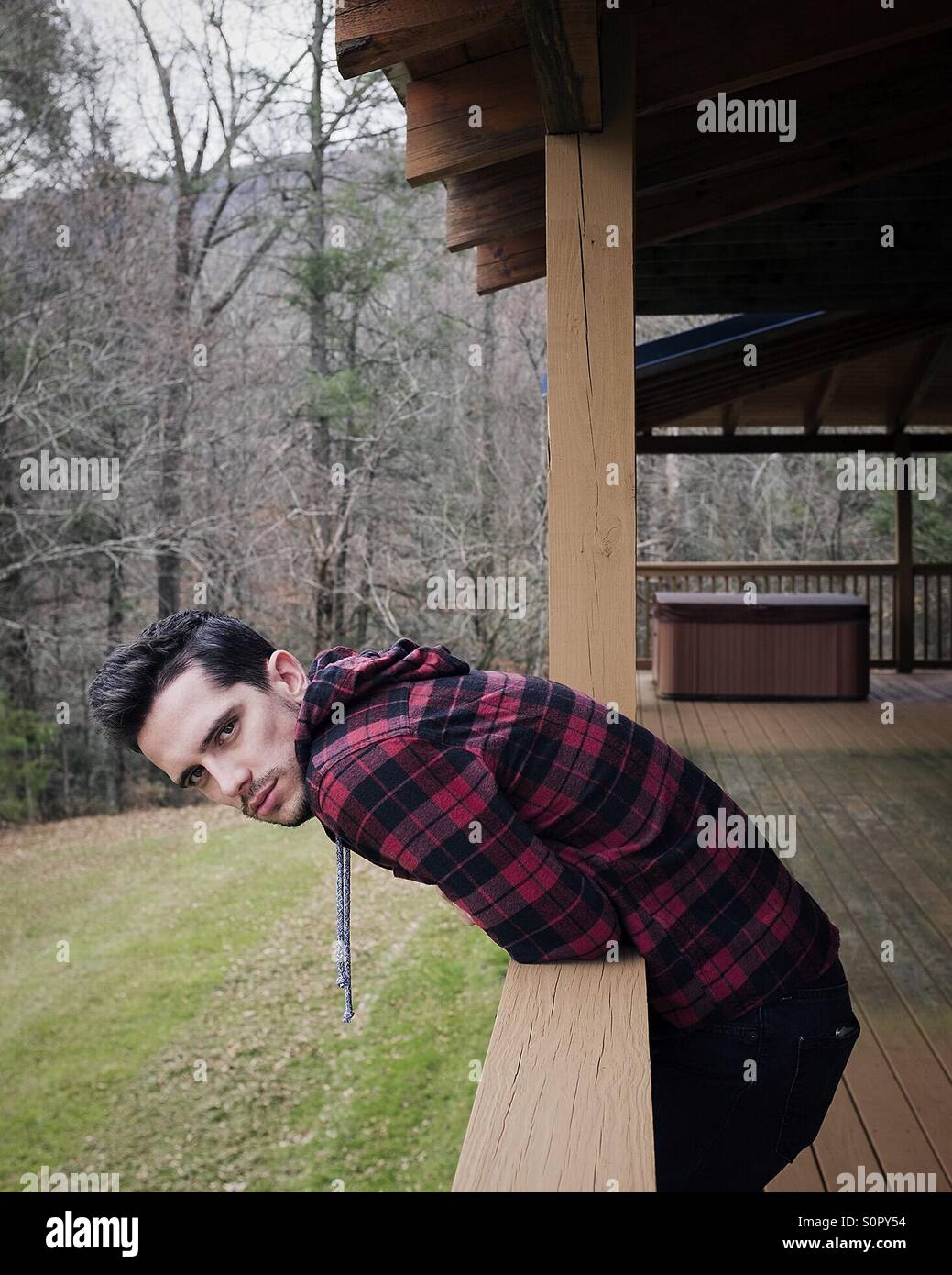 Junge auf Veranda im Wald Stockfoto